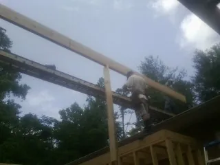 Carpenter setting a ridge beam over a new addition frame — Ice Dam Removal by Roofing Brothers in Palm Bay