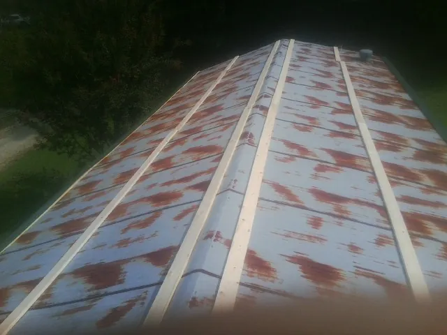 Rusted metal roof panels with new wood purlins before replacement — Storm Damage Roof Repair in Palm Bay by Roofing Brothers