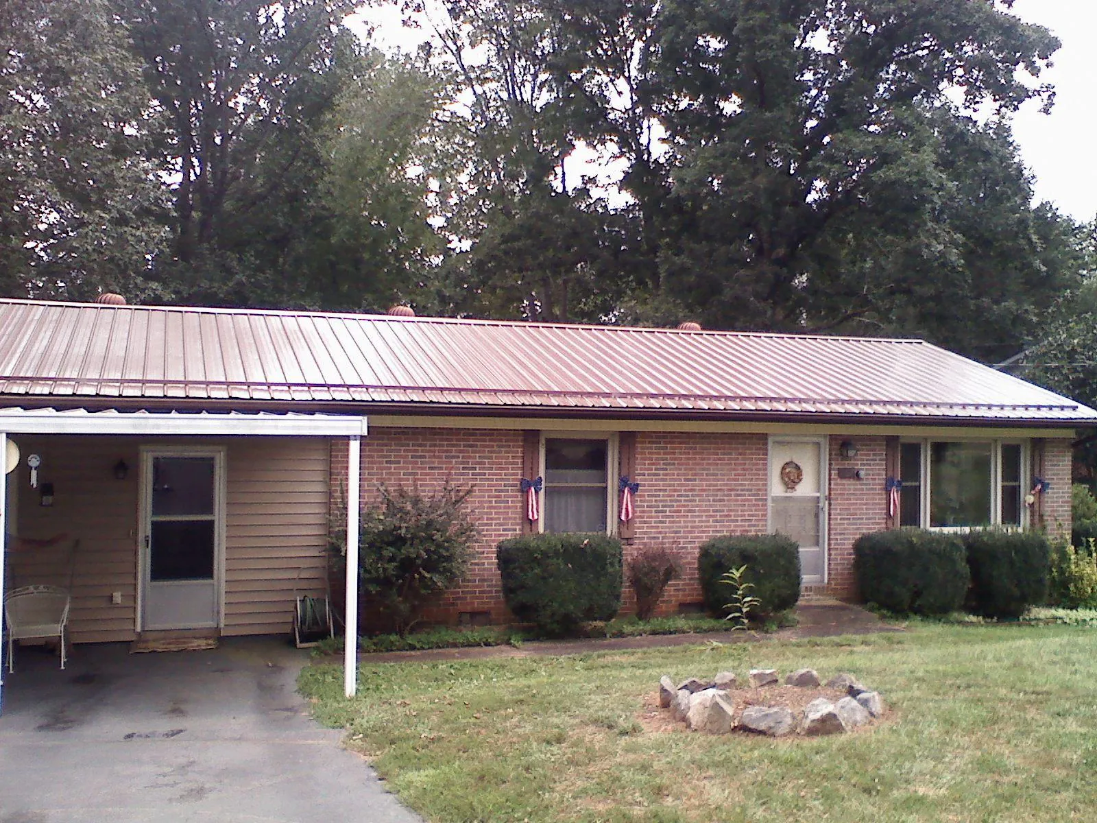 Bronze metal roof and carport on a brick ranch home — Roof Repair work by our crew in Palm Bay